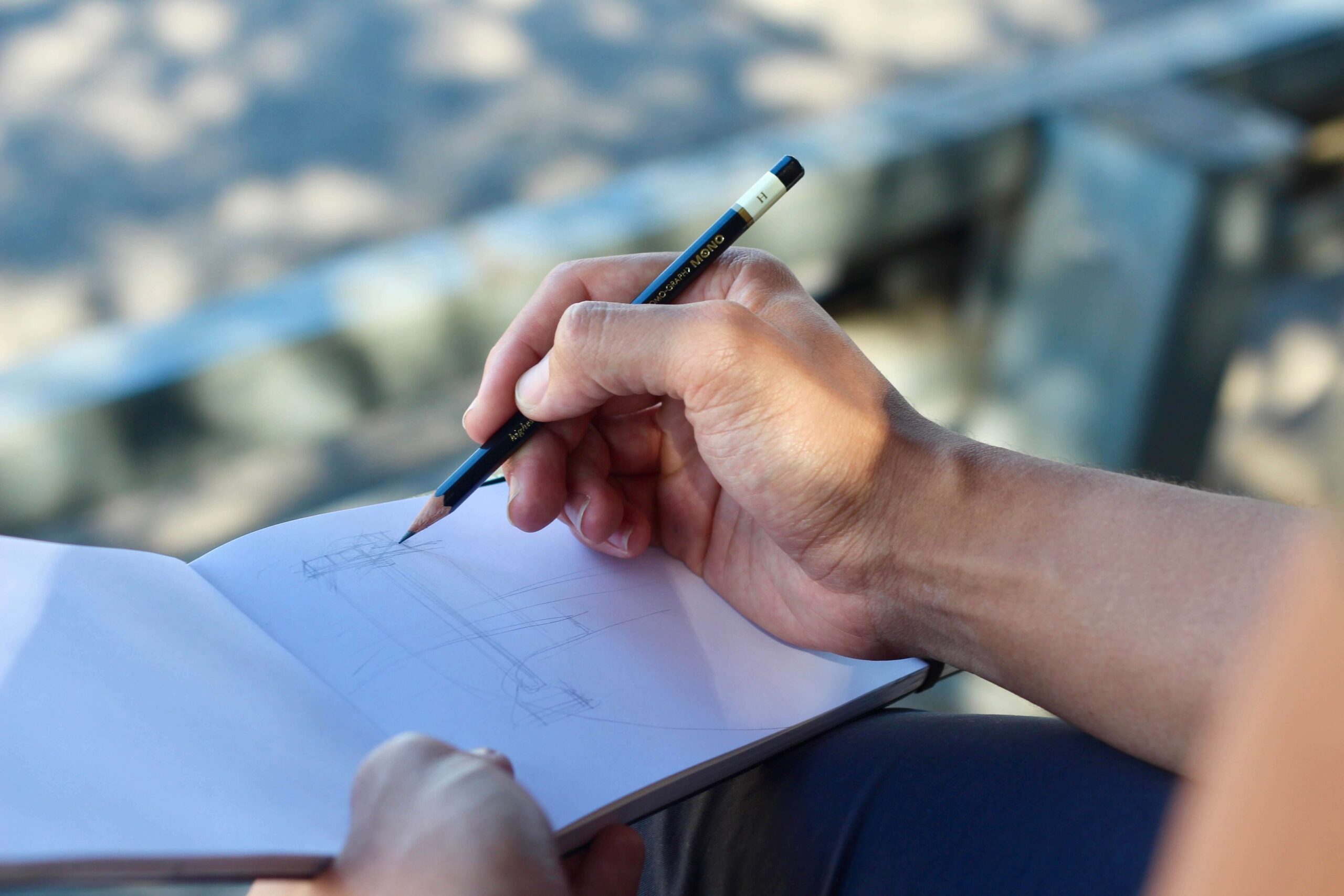 Person drawing figures with the pencil in a bloknot. Drawing therapy. Mindletic Blog