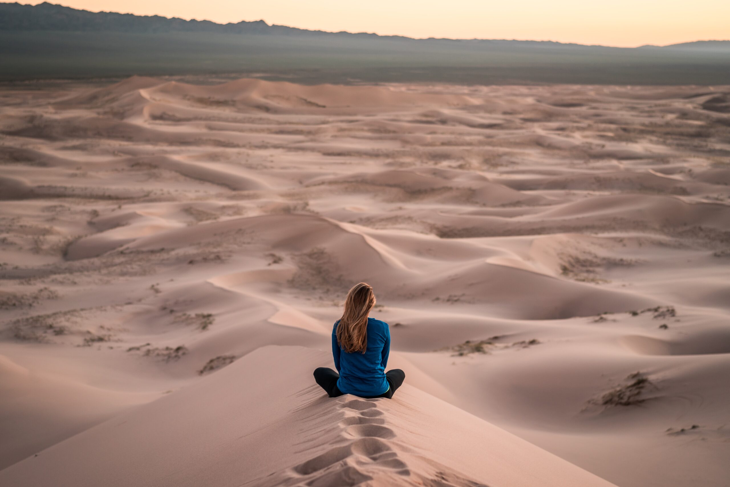 Young woman sitting in the desert looking for peace. Mindfulness practice. Mindletic Blog