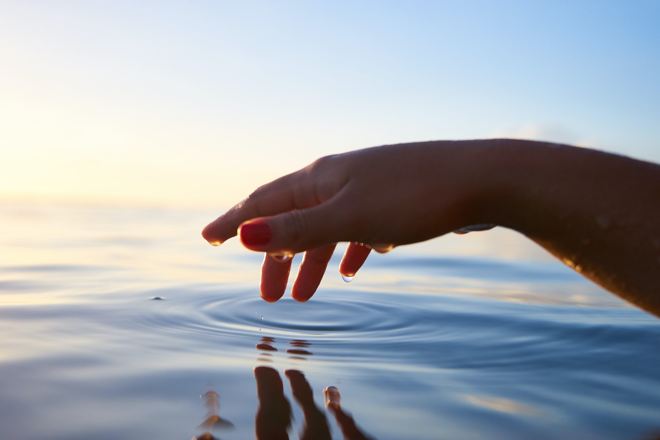 Hand touching water. How to recover from burnout without quitting? Mindletic Blog
