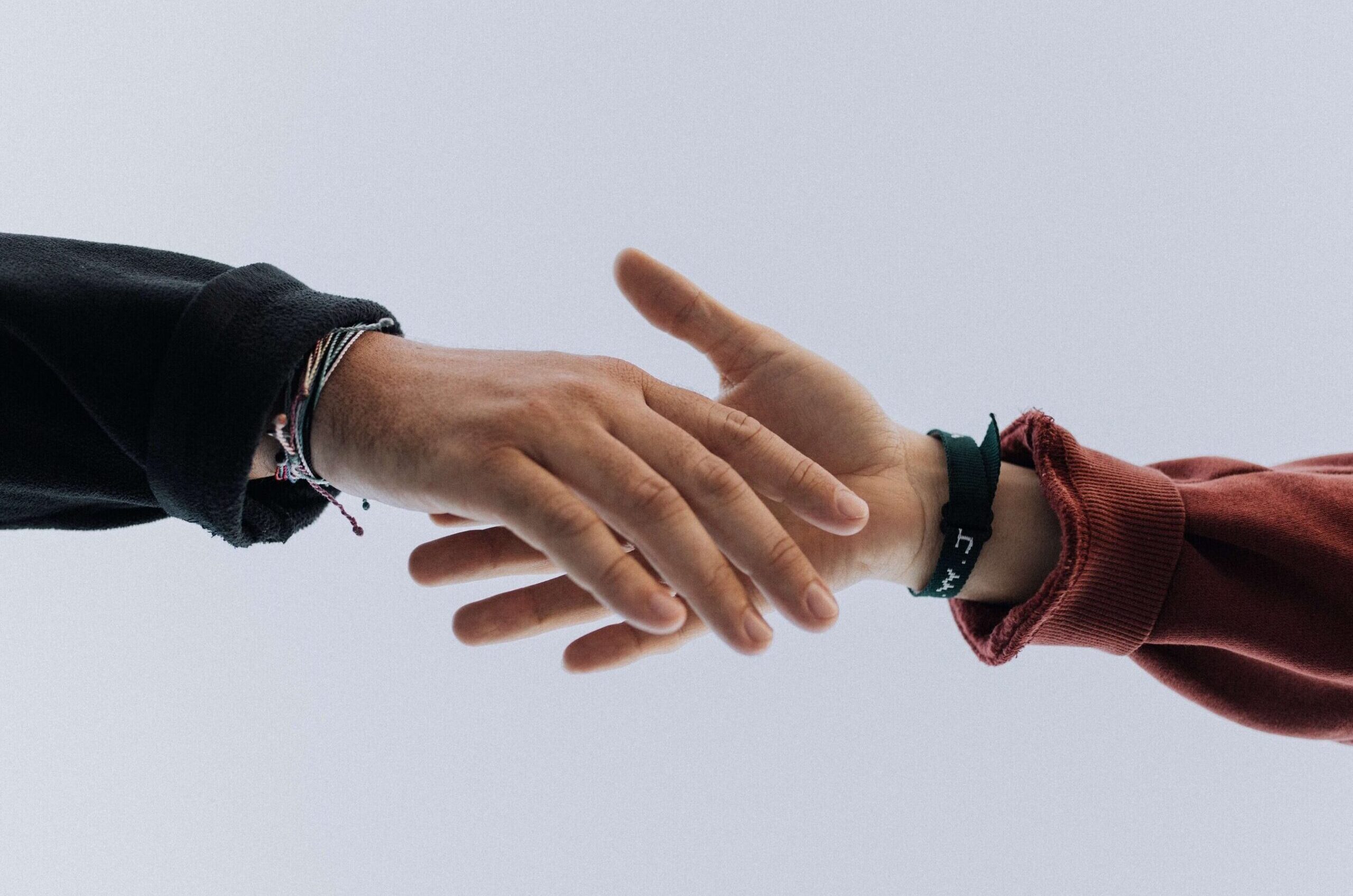 Shaking hands. Managing conflicts int the workplace. Mindletic Blog