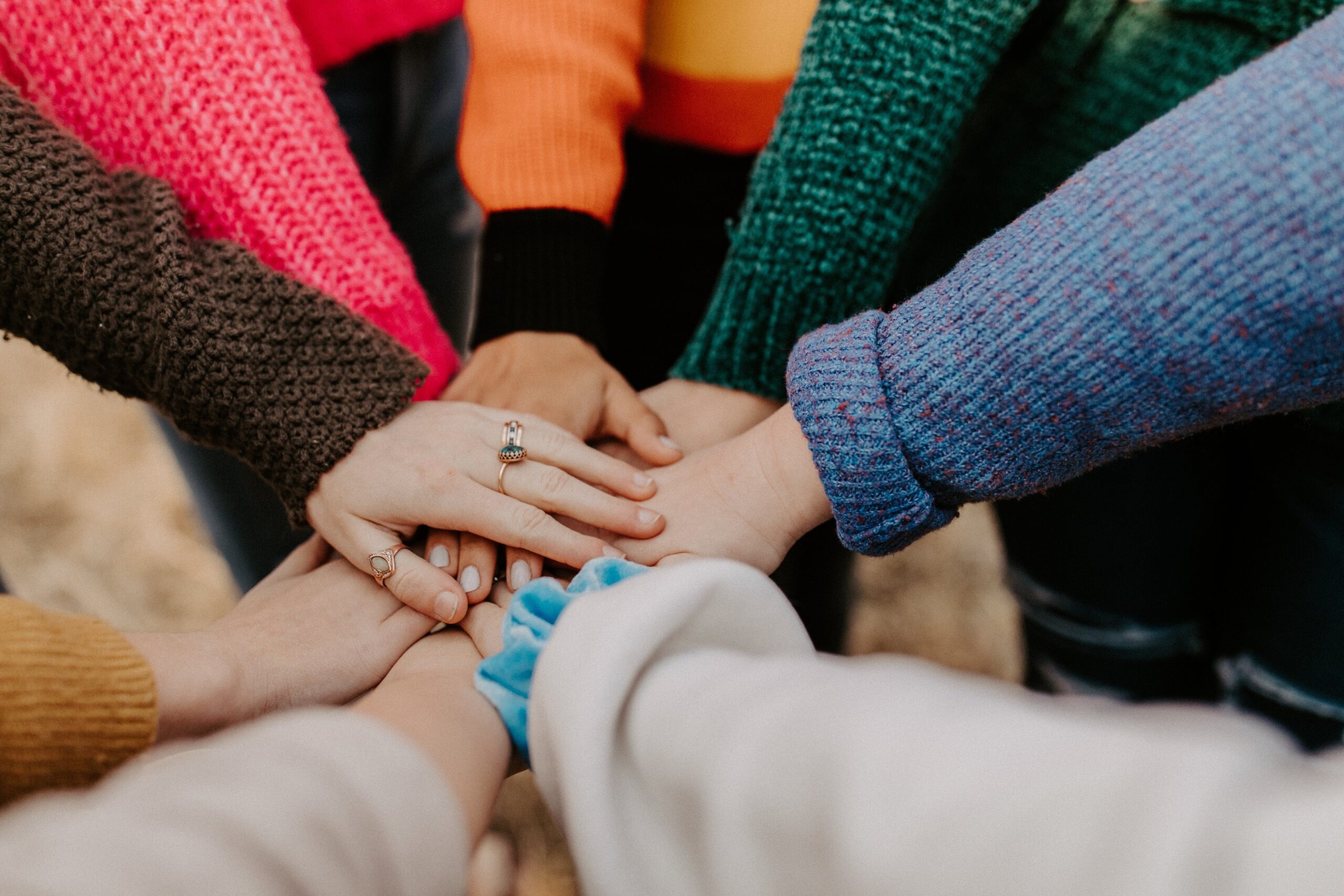 People holding hands in center, organizational culture. Mindletic Blog