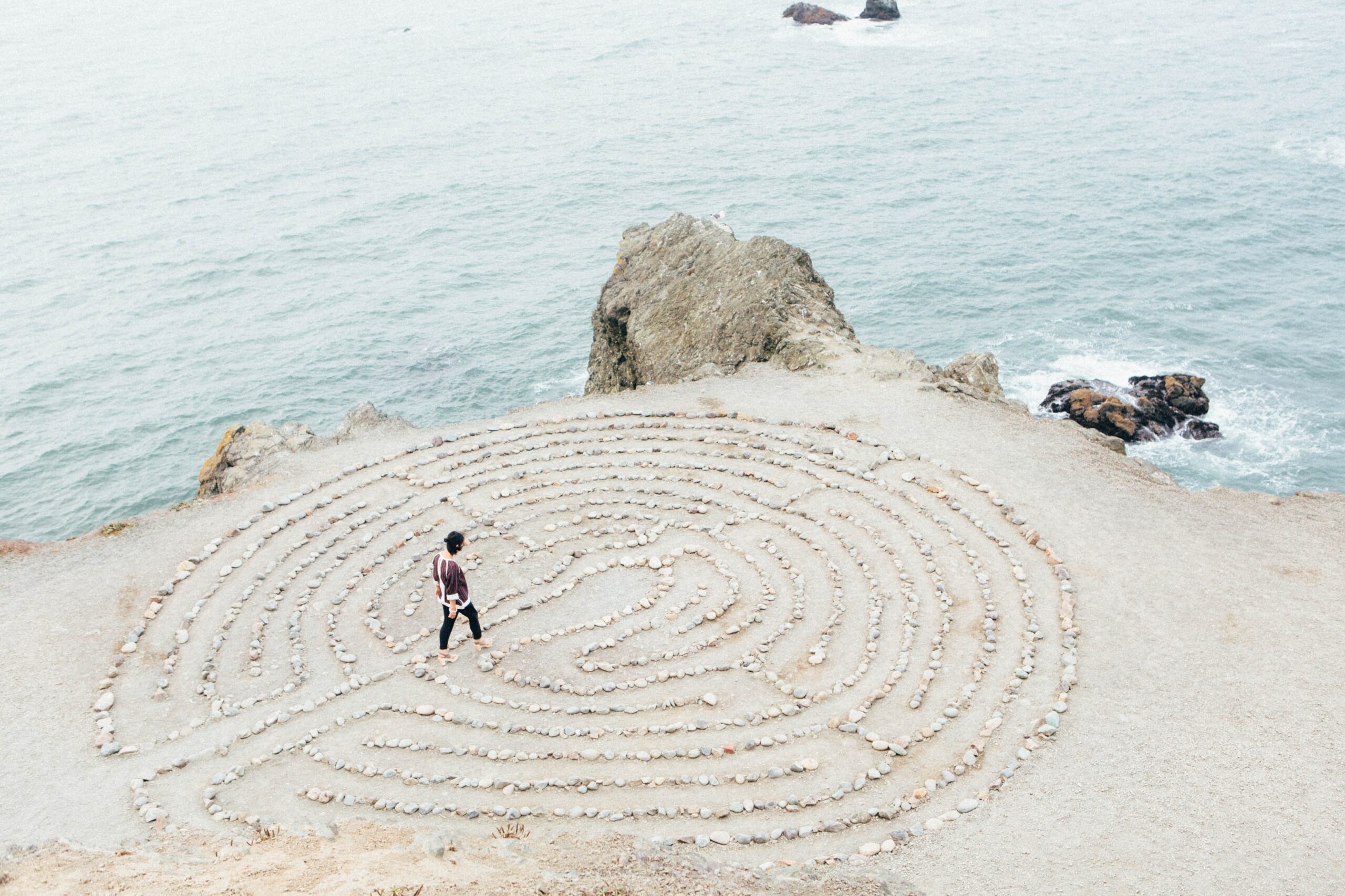 Woman walking in the labyrinth. Tracking emotions is a way to improve emotional well-being. Mindletic Blog