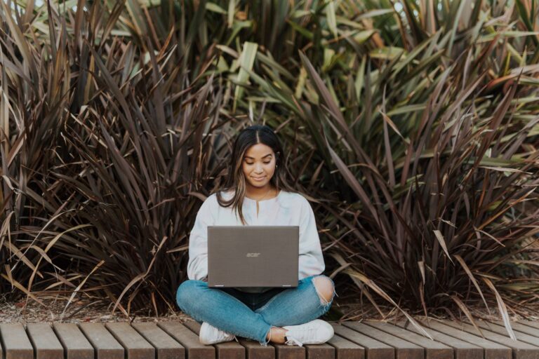 A woman sitting with a laptop, employee engagement, Mindletic blog.