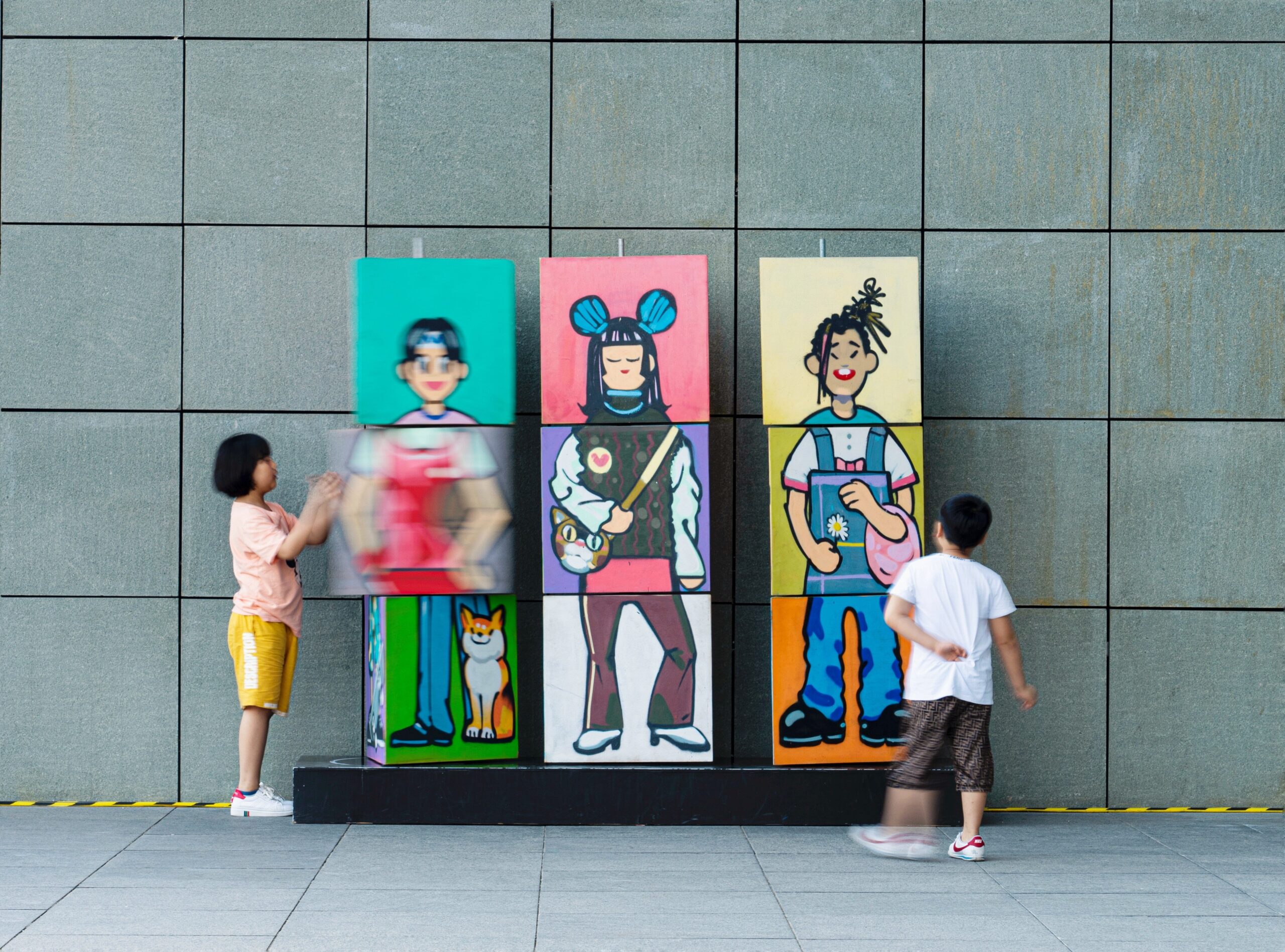 two kids near the colorful wall. The phenomenon of impostor syndrome. Mindletic blog