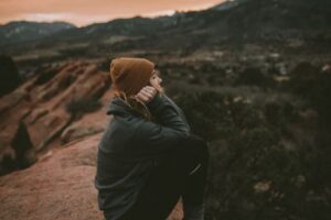 Burned-out girl sitting on a mountain